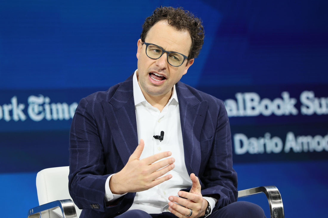Man in glasses and a dark blazer speaking on a DealBook Summit stage
